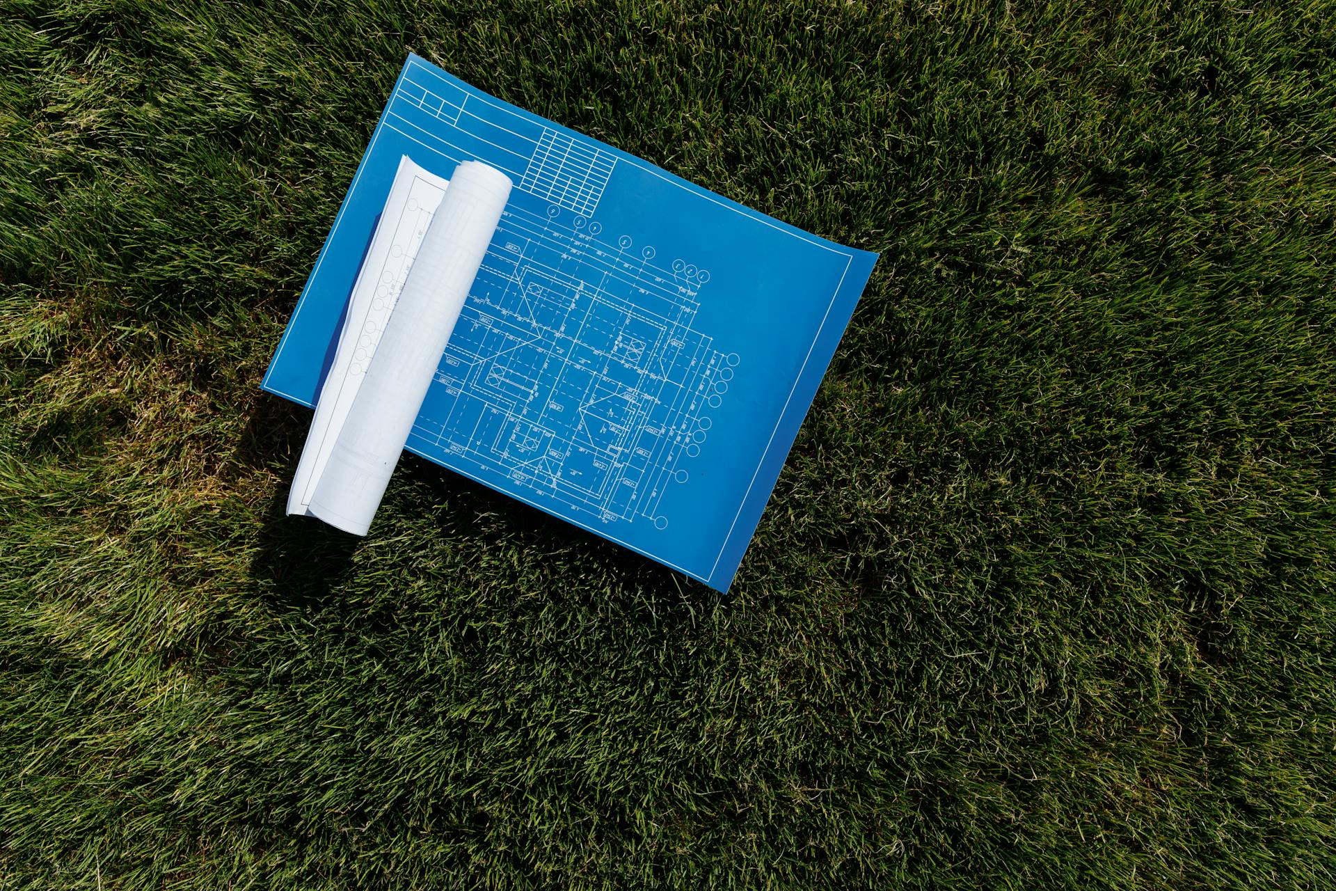Blueprint laid out on site ready for construction, illustrating planning to avoid project delays and fines